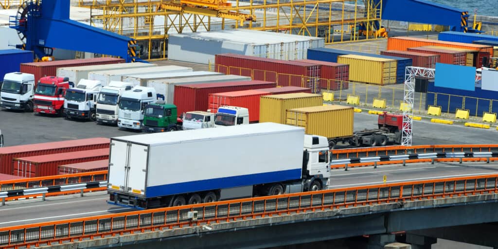 Freight truck crossing a bridge at a busy container port.