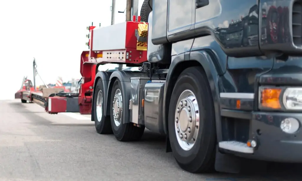 Heavy haul truck cab hitched to a lowboy trailer dolly.