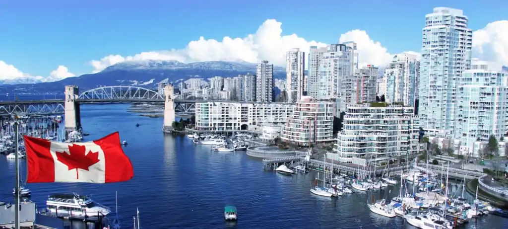 Canadian flag flying over Vancouver harbor with city skyline