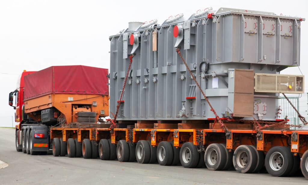 Heavy haul modular trailer transporting a large industrial transformer.